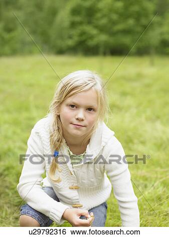 Young girl in a field outdoors. View Large Photo Image Stock Photograph - Young girl in a field outdoors.. Fotosearch