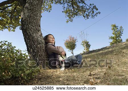 Young girl leaning against a tree. View Large Photo Image Stock Photography - Young girl leaning against a tree.. Fotosearch