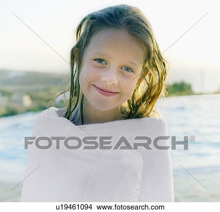 Young girl wrapped in towel by pool smiling. View Large Photo Image Picture - Young girl wrapped in towel by pool smiling.. Fotosearch