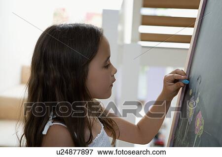 Young girl writing on a chalk board. View Large Photo Image Stock Photo - Young girl writing on a chalk board.. Fotosearch