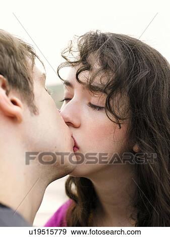 Stock Photo - Close up portrait of woman kissing man. Fotosearch