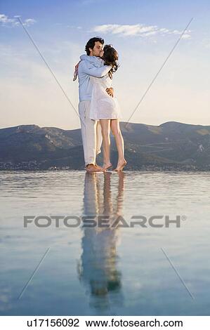 Couple kissing by infinity pool. View Large Photo Image Stock Image - Couple kissing by infinity pool.. Fotosearch