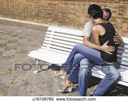 Stock Photography - Couple kissing on a bench.. Fotosearch