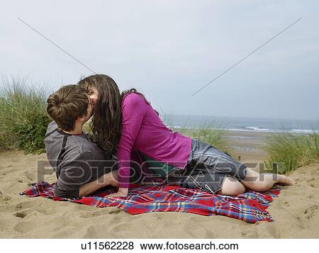 Couple kissing on blanket on sand dune View Large Photo Image Stock Photo - Couple kissing on blanket on sand dune. Fotosearch