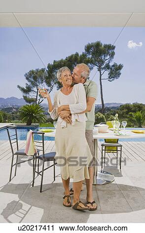 Man and woman embracing by poolside. View Large Photo Image Stock Image - Man and woman embracing by poolside.. Fotosearch