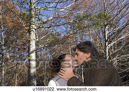 Stock Image - Portrait of a couple surrounded by trees.. Fotosearch