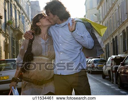 Pregnant young woman and young man kissing in street View Large Photo Image Stock Image - Pregnant young woman and young man kissing in street. Fotosearch