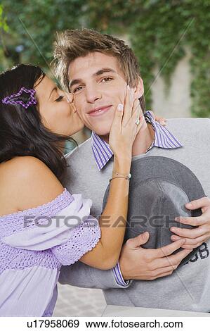 Stock Photo - Woman kissing man on cheek.. Fotosearch