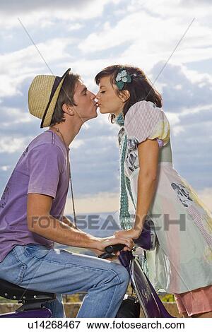 Woman kissing man on scooter. View Large Photo Image Stock Photo - Woman kissing man on scooter.. Fotosearch