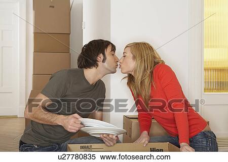 Young couple kissing over cardboard box, eyes closed View Large Photo Image Stock Photography - Young couple kissing over cardboard box, eyes closed. Fotosearch