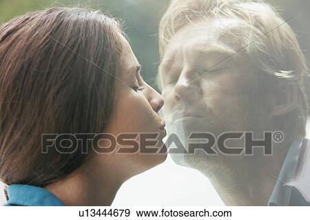 Young couple kissing through glass of window. View Large Photo Image Stock Photo - Young couple kissing through glass of window.. Fotosearch