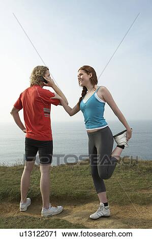 A man holds a phone and woman stretches. View Large Photo Image Stock Image - A man holds a phone and woman stretches.. Fotosearch