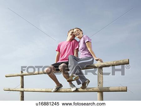 A Young couple sit on a country fence. View Large Photo Image Stock Photography - A Young couple sit on a country fence.. Fotosearch