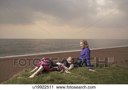 Couple sitting next to a beach. View Large Photo Image Stock Image - Couple sitting next to a beach.. Fotosearch