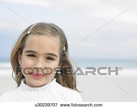 Girl (6-8) on beach smiling, portrait, close-up View Large Photo Image Stock Photo - Girl (6-8) on beach smiling, portrait, close-up. Fotosearch