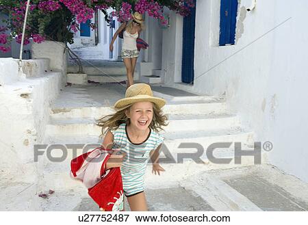 Woman and young girl running outside house smiling with towels. View Large Photo Image Stock Photo - Woman and young girl running outside house smiling with towels.. Fotosearch