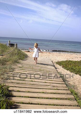 Young boy walking on a wooden path at the beach. View Large Photo Image Stock Image - Young boy walking on a wooden path at the beach.. Fotosearch