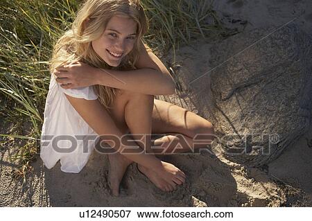 Young Woman Sitting at edge of beach. View Large Photo Image Stock Photo - Young Woman Sitting at edge of beach.. Fotosearch