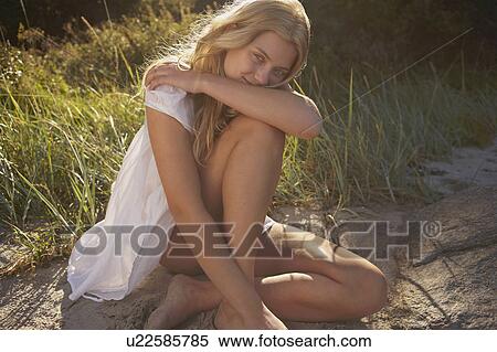 Young Woman Sitting at edge of beach. View Large Photo Image Stock Photography - Young Woman Sitting at edge of beach.. Fotosearch