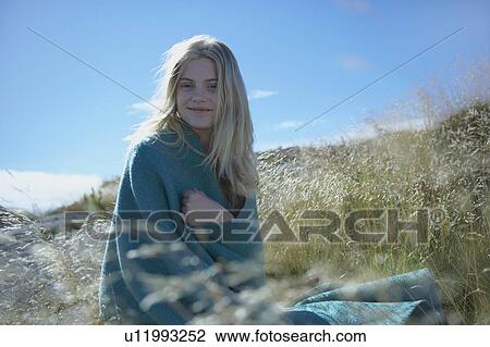 Stock Image - Young Woman Sitting in Long grass.. Fotosearch