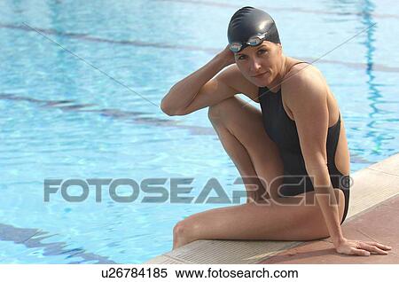Female swimmer sitting on edge of pool, portrait View Large Photo Image Stock Photography - Female swimmer sitting on edge of pool, portrait. Fotosearch