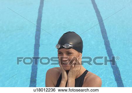 Female swimmer standing by pool, smiling View Large Photo Image Stock Photograph - Female swimmer standing by pool, smiling. Fotosearch