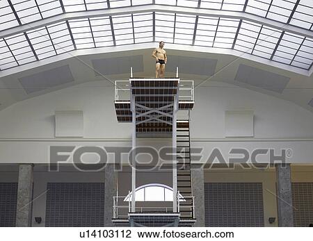 Stock Image - mature man on diving board low angle view. Fotosearch