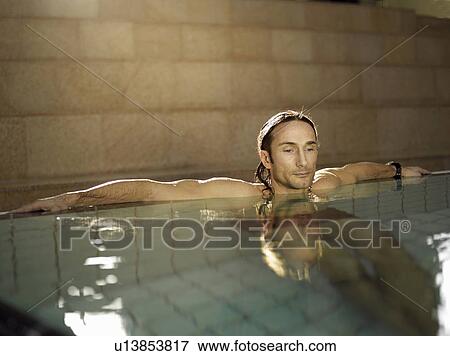 Stock Photo - Mature man sitting in swimming pool. Fotosearch