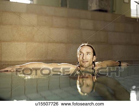 Stock Photograph - Mature man sitting in swimming pool. Fotosearch