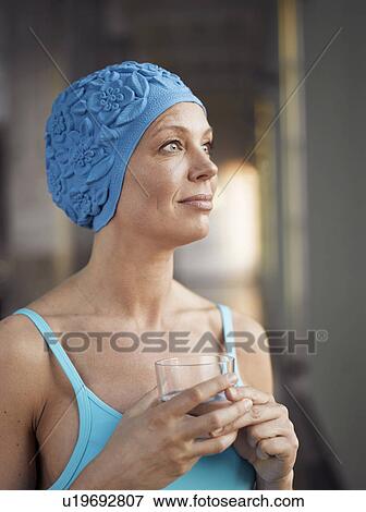 Mature woman wearing bathing suit, holding glass of water View Large Photo Image Stock Photo - Mature woman wearing bathing suit, holding glass of water. Fotosearch