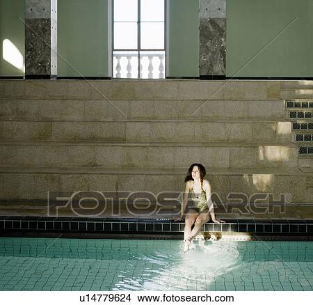 Picture - Woman sitting by swimming pool. Fotosearch