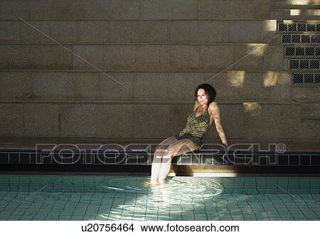 Picture - Woman sitting by swimming pool. Fotosearch