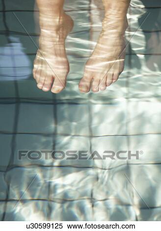 Woman's feet under water in swimming pool, elevated view View Large Photo Image Stock Photography - Woman's feet under water in swimming pool, elevated view. Fotosearch