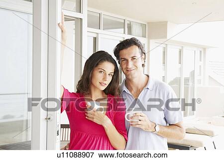 Couple at home looking relaxed, smiling View Large Photo Image Stock Photo - Couple at home looking relaxed, smiling. Fotosearch