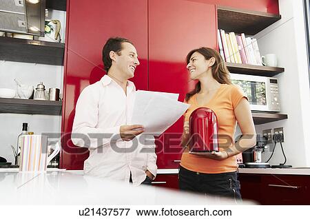 Couple discuss paperwork in kitchen View Large Photo Image Stock Photo - Couple discuss paperwork in kitchen. Fotosearch