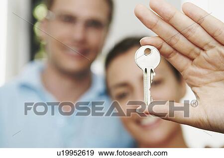 Stock Photo - Couple hold key to new property. Fotosearch