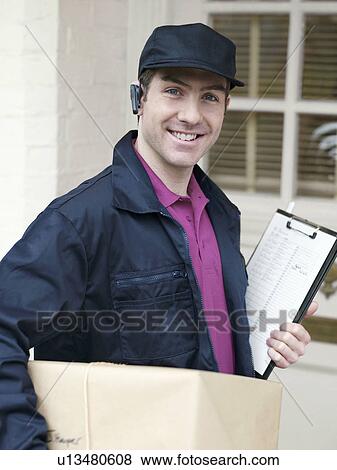 Courier with large parcel at front door View Large Photo Image Stock Photo - Courier with large parcel at front door. Fotosearch
