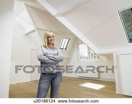Smiling woman arms crossed into empty white loft. View Large Photo Image Picture - Smiling woman arms crossed into empty white loft.. Fotosearch