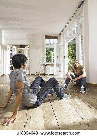 Two friends seated on floor of empty house. View Large Photo Image Stock Photo - Two friends seated on floor of empty house.. Fotosearch
