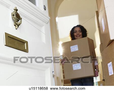 Stock Photo - Woman carrying boxes of goods to door. Fotosearch