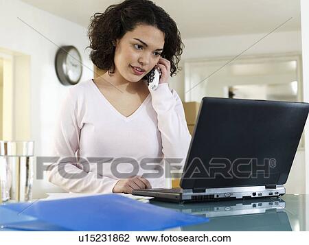 Woman on phone with laptop View Large Photo Image Stock Image - Woman on phone with laptop. Fotosearch