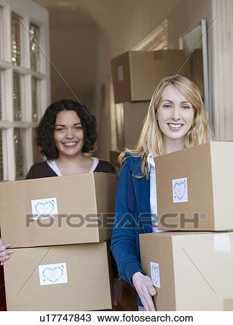 Stock Image - Women with boxes of goods in doorway. Fotosearch