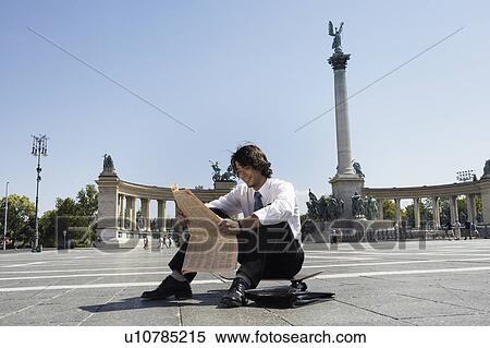 Businessman reading newspaper in Hero Square. View Large Photo Image Stock Photography - Businessman reading newspaper in Hero Square.. Fotosearch