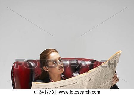 Businesswoman in a comfy leather chair with newspaper View Large Photo Image Stock Image - Businesswoman in a comfy leather chair with newspaper. Fotosearch