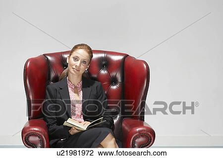Stock Image - Businesswoman in a comfy leather chair. Fotosearch
