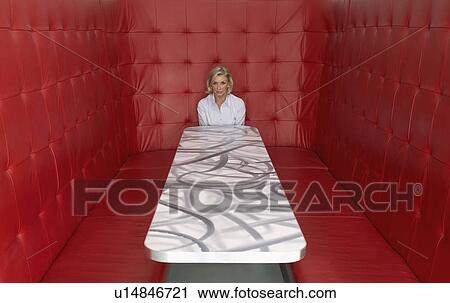 Businesswoman working at a table with red seating View Large Photo Image Stock Image - Businesswoman working at a table with red seating. Fotosearch