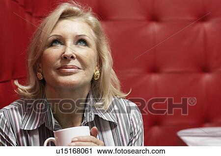 Businesswoman working at a table with red seating View Large Photo Image Stock Image - Businesswoman working at a table with red seating. Fotosearch
