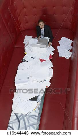 Businesswoman working at a table with red seating View Large Photo Image Stock Image - Businesswoman working at a table with red seating. Fotosearch