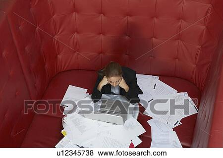 Businesswoman working at a table with red seating View Large Photo Image Stock Photo - Businesswoman working at a table with red seating. Fotosearch