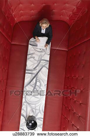 Stock Photo - Businesswoman working at a table with red seating. Fotosearch